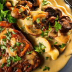 Mushroom Steak Diane plated with golden-brown seared mushrooms in savory sauce, garnished with fresh parsley, served with a side of vegetables.