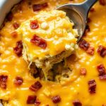 Cheesy Amish Breakfast Casserole with bacon and melted cheese in a white baking dish