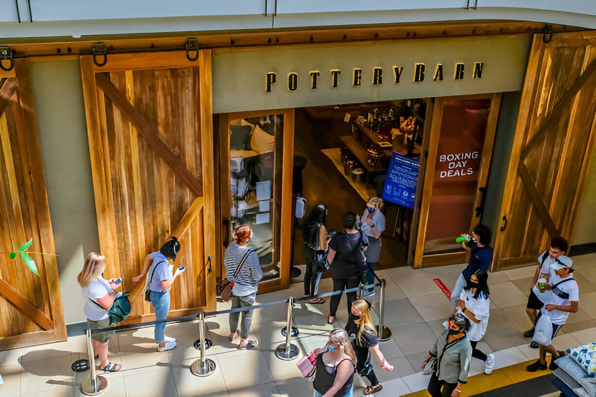 Customers waiting in line at a Pottery Barn store entrance, ready to shop the Boxing Day sales.